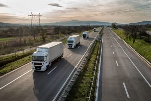 Caravana o convoy de camiones en fila en una carretera rural